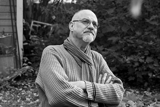 Michael Marnin Jacobs sits in a garden.